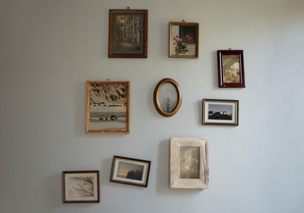 golden vintage frames with black and white old pictures inside on the white wall